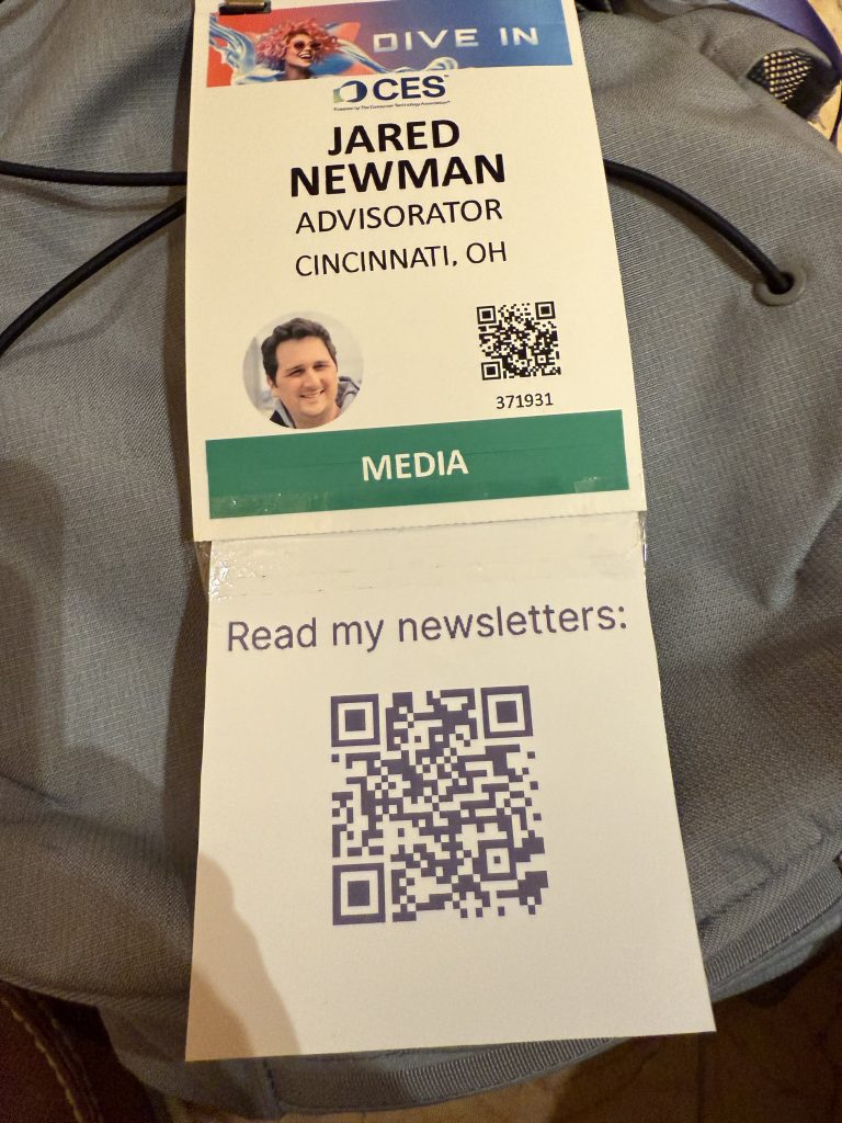 A CES badge for Jared Newman of Advisorator, with a taped-on portion that says “Read my newsletters” and has a QR code.